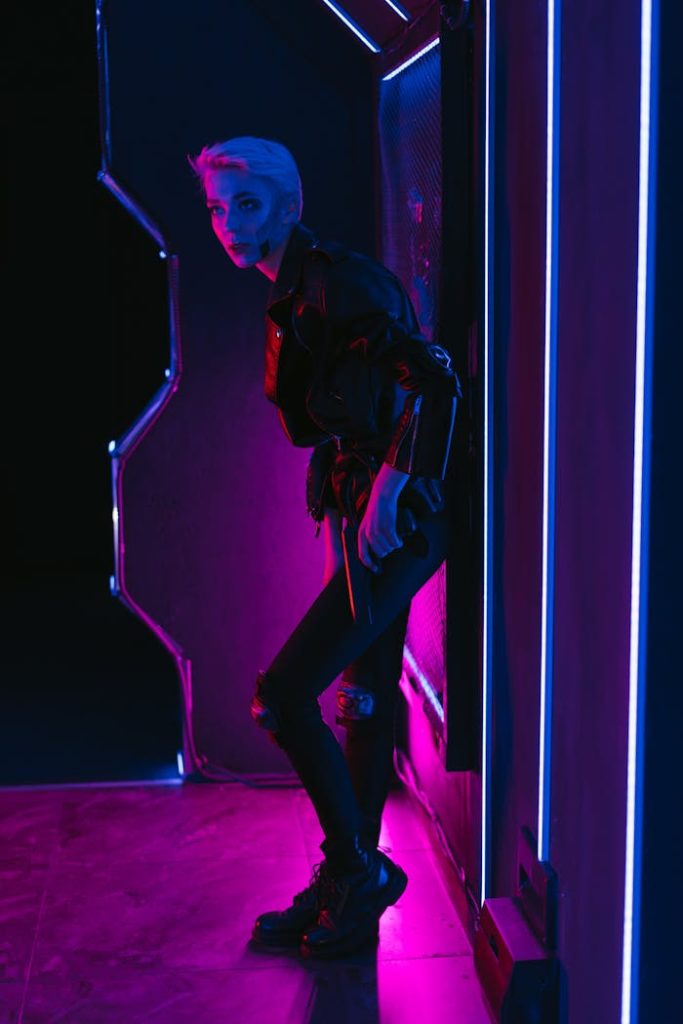 Stylish woman in cyberpunk outfit illuminated by vibrant neon lights.